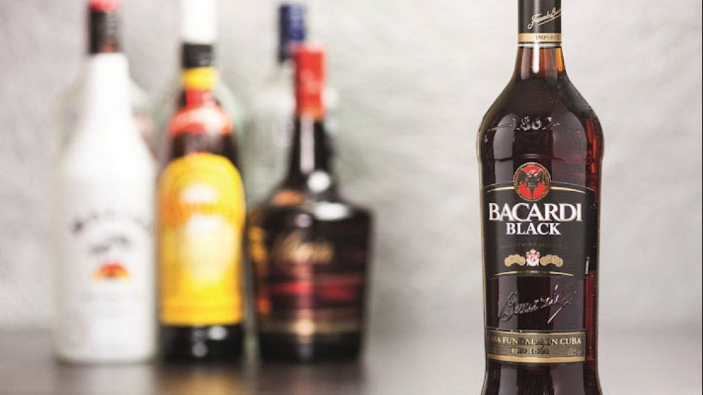 eine Flasche kubanischer Rum, Bacardi, mit mehreren anderen Flaschen im Hintergrund ()